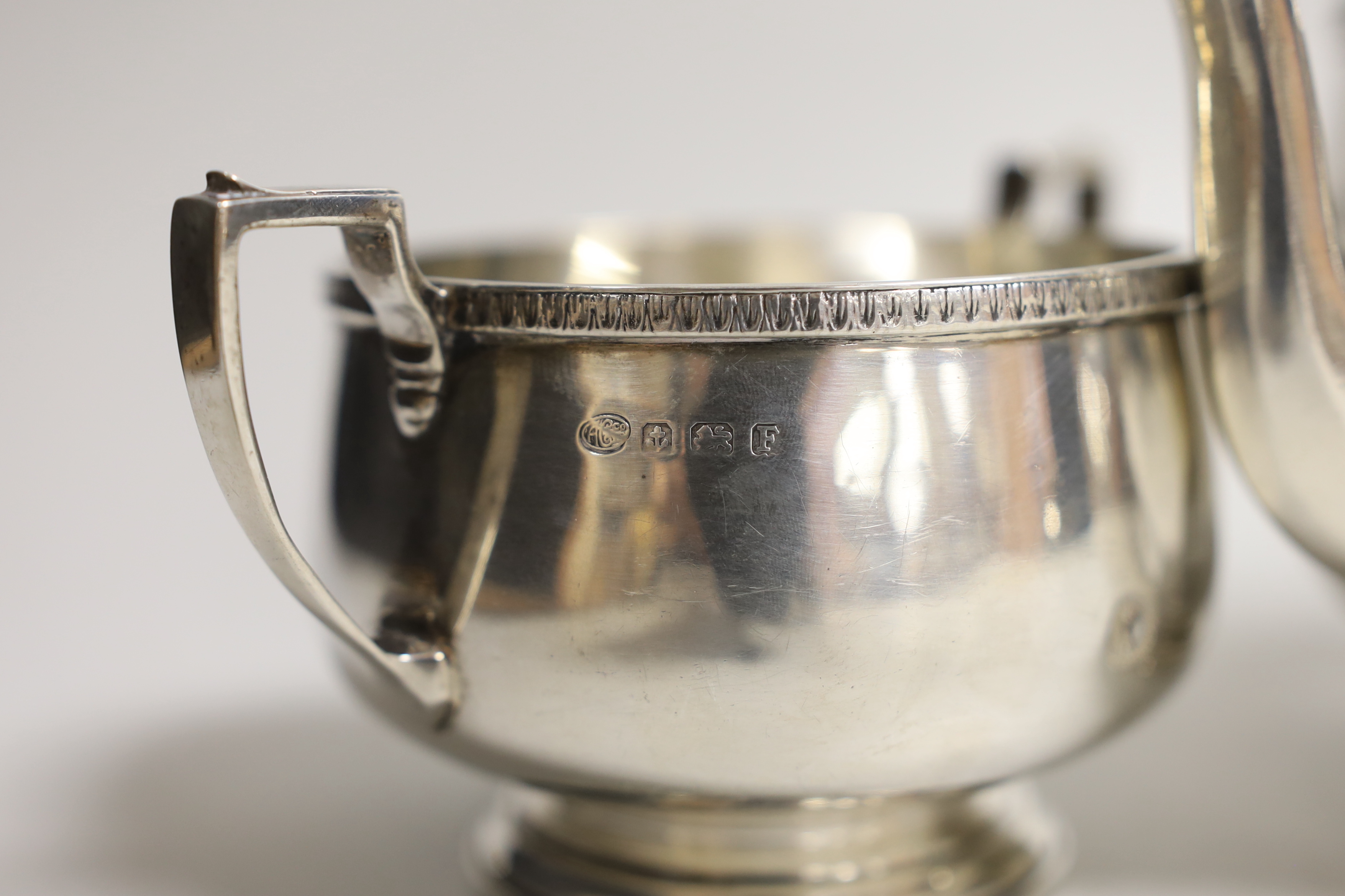 A George V silver circular three piece tea set, Alexander Clark Co, Birmingham, 1930, gross weight 26.3oz.